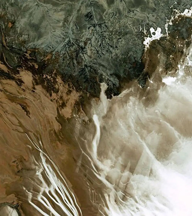 Olive & Foam - Aerial view of a mountainous landscape with a river flowing through it.